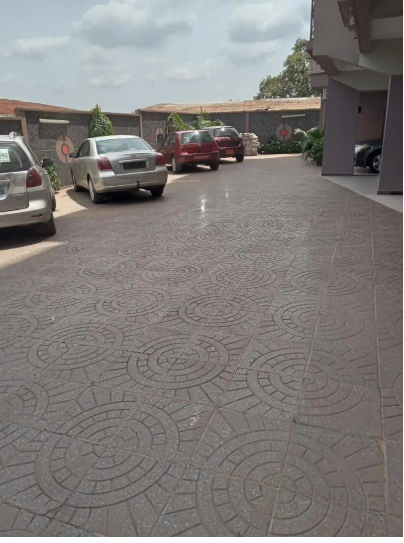 Parking pavé de la résidence avec plusieurs véhicules garés