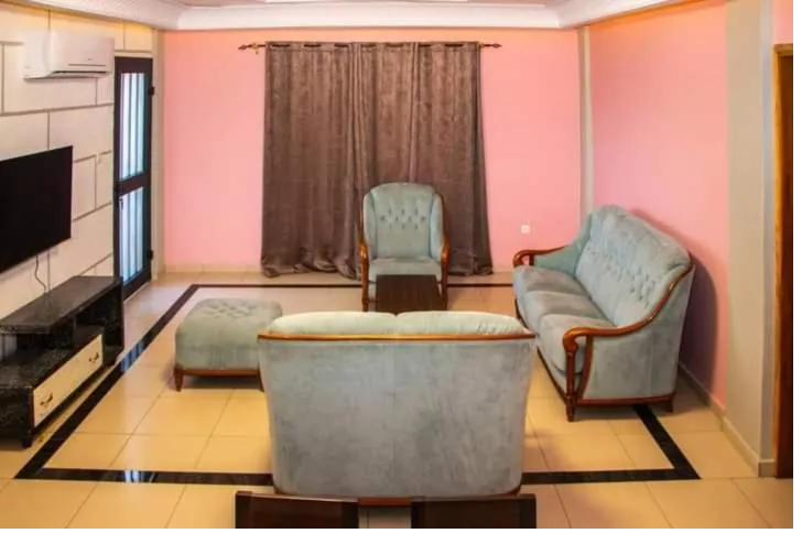 Salon d'appartement avec fauteuils capitonnés et grandes baies